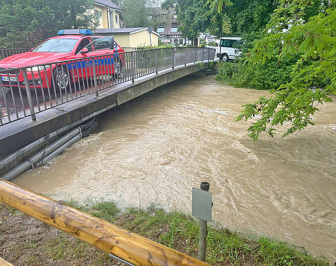 Brücke mit Feuerwehrauto und hoher Wasserstand